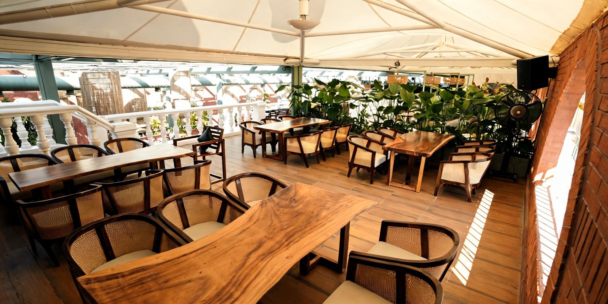 Rooftop deck at Bier Loft with live-edge wooden tables and cane chairs